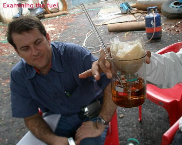 Un Delegado Extranjero comprobando el petroleo obtenido a partir de botellas de plástico