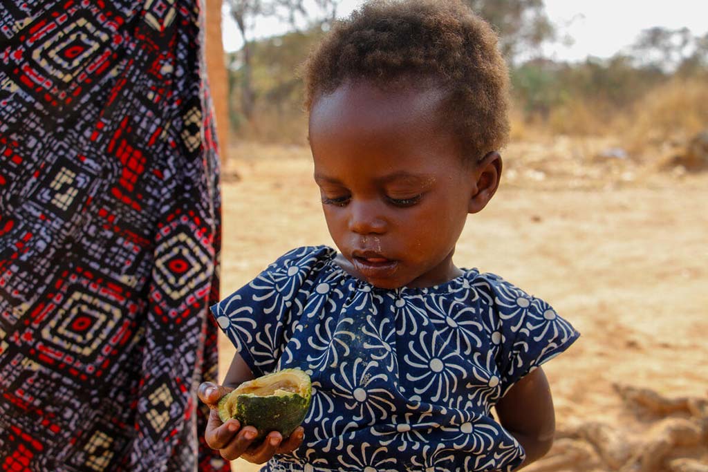 La pequeña Isabel con un "maboque",fruta (típica del sur
Angola). Foto cortesía de World Vision.